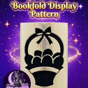 Könnte beinhalten: Ein Buchfaltmuster mit einem Korbmotiv mit Eiern und einer Schleife. Der Text "Bookfold Display Pattern" ist in Gold gehalten. Der Hintergrund ist lila mit Sternen und einem Mond.