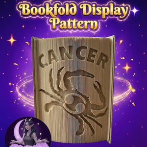 Op de afbeelding: Een boekvouwpatroon met het sterrenbeeld Kreeft uitgesneden in de pagina's. Het woord "CANCER" is in het boek gesneden, met het krabsymbool eronder. De achtergrond is paars met sterren en de tekst "Bookfold Display Pattern".
