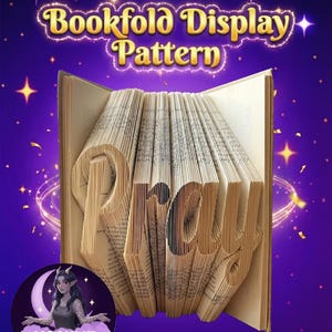 Może przedstawiać: Książka ze stronami złożonymi w słowo "Pray". Obraz ma fioletowe tło z gwiazdami i tekst "Bookfold Display Pattern". Logo Moonlit Munchkin Creations znajduje się w lewym dolnym rogu.