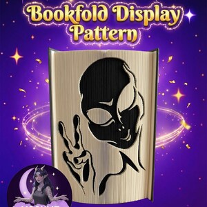Könnte beinhalten: Ein Buchfalt-Displaymuster mit einem schwarzen Alien-Design und einem Friedenszeichen, das in die Seiten geschnitten ist. Der Text "Bookfold Display Pattern" befindet sich oben. Der Hintergrund ist lila mit Sternen und einem Mondlogo.