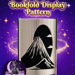 Könnte beinhalten: Ein Buchfalt-Display-Muster mit einer Berglandschaft, die in die Seiten geschnitten ist. Der Text "Bookfold Display Pattern" ist goldfarben mit einem Glitzereffekt. Der Hintergrund ist lila mit Sternen und einem Logo.