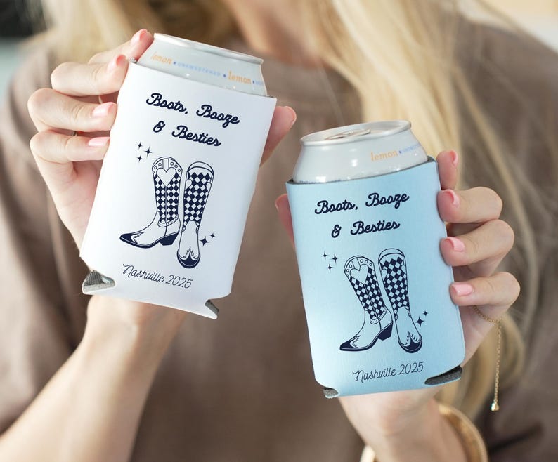 K&ouml;nnte beinhalten: Zwei Getr&auml;nke-K&uuml;hlmanschetten, eine wei&szlig;e und eine hellblaue, jeweils mit einem Design mit Cowboy-Stiefeln und dem Text "Boots, Booze & Besties" und "Nashville 2025".