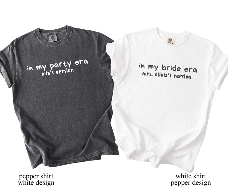 May include: Two t-shirts, one dark gray and one white, with text. The dark gray shirt says "in my party era mia's version." The white shirt says "in my bride era mrs. olivia's version."
