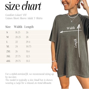 May include: Size chart for Comfort Colors 1717 unisex short sleeve adult t-shirts. Sizes range from S to 4XL, with width measurements from 18.25 to 29.75 inches and lengths from 26 to 33.5 inches. The model is wearing a Large.