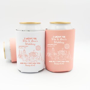 May include: White and coral-colored can coolers with gold rims. The coolers have the text "I WENT TO Wes & Ana's Wedding" and "AND ALL I GOT WAS THIS lousy shirt" printed on them, along with wedding-themed illustrations.