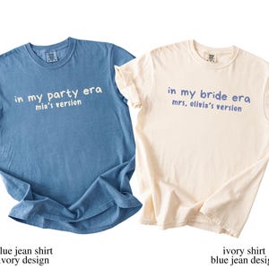 May include: Two t-shirts, one blue and one ivory, with text. The blue shirt says "in my party era mia's version" in white. The ivory shirt says "in my bride era mrs. olivia's version" in blue. Both shirts are short-sleeved.