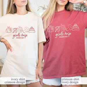 May include: Two oversized t-shirts, one ivory and one crimson, each featuring a graphic with a pumpkin, leaf, coffee cup, pretzel, and hat. The text "girls trip VERMONT/2021" is printed below the graphic.