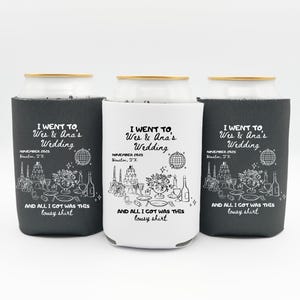 May include: Three beverage can coolers, two in dark gray and one in white. Each cooler features the text "I WENT TO Wes & Ana's Wedding" with event details and a humorous phrase. The design includes illustrations of wedding elements.
