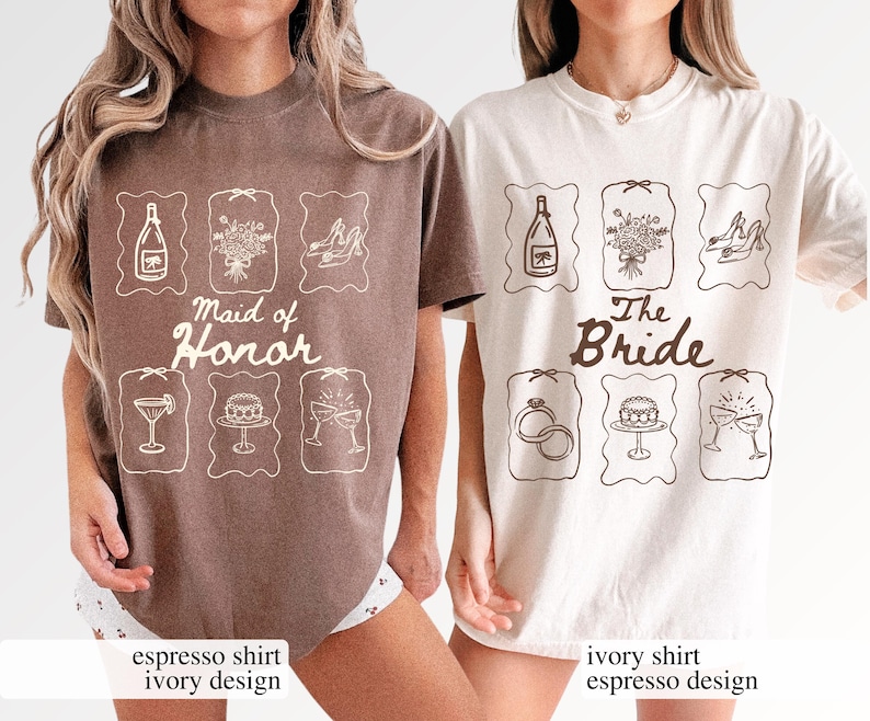May include: Two t-shirts, one in espresso and one in ivory, display wedding-related designs. The espresso shirt reads "Maid of Honor", while the ivory shirt says "The Bride". Both shirts have matching illustrations of a champagne bottle, bouquet, shoes, and other items.