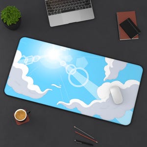 May include: A rectangular mouse mat with a blue sky design, featuring white clouds, geometric shapes, and a bright sun. A white computer mouse rests on the mat. The mat is surrounded by a black border.