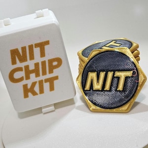 May include: A white rectangular box with the text "NIT CHIP KIT" in gold lettering. Beside the box is a stack of hexagonal chips with the word "NIT" in gold, set against a black background, and a gold border.