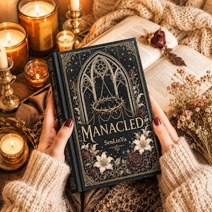 May include: A black book titled "MANACLED" with gold accents, a gothic window design, and a crown of thorns. The book is held by a person wearing a beige sweater. The background includes lit candles and an open book.