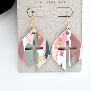 May include: A white ceramic mug with a black handle and the text "But First, Coffee" in a bold, black font. The mug is set against a blurred background, suggesting a cozy setting.