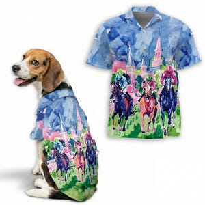 May include: A beagle dog wearing a shirt with a watercolour horse racing design. The shirt shows jockeys on horses, a blue sky, and pink buildings. A matching shirt is displayed separately.