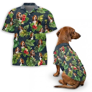 May include: A short-sleeved button-down shirt and a dog shirt with a repeating pattern of basset hounds, tropical flowers, and large green leaves on a dark blue background. The dog shirt is on a brown dachshund.