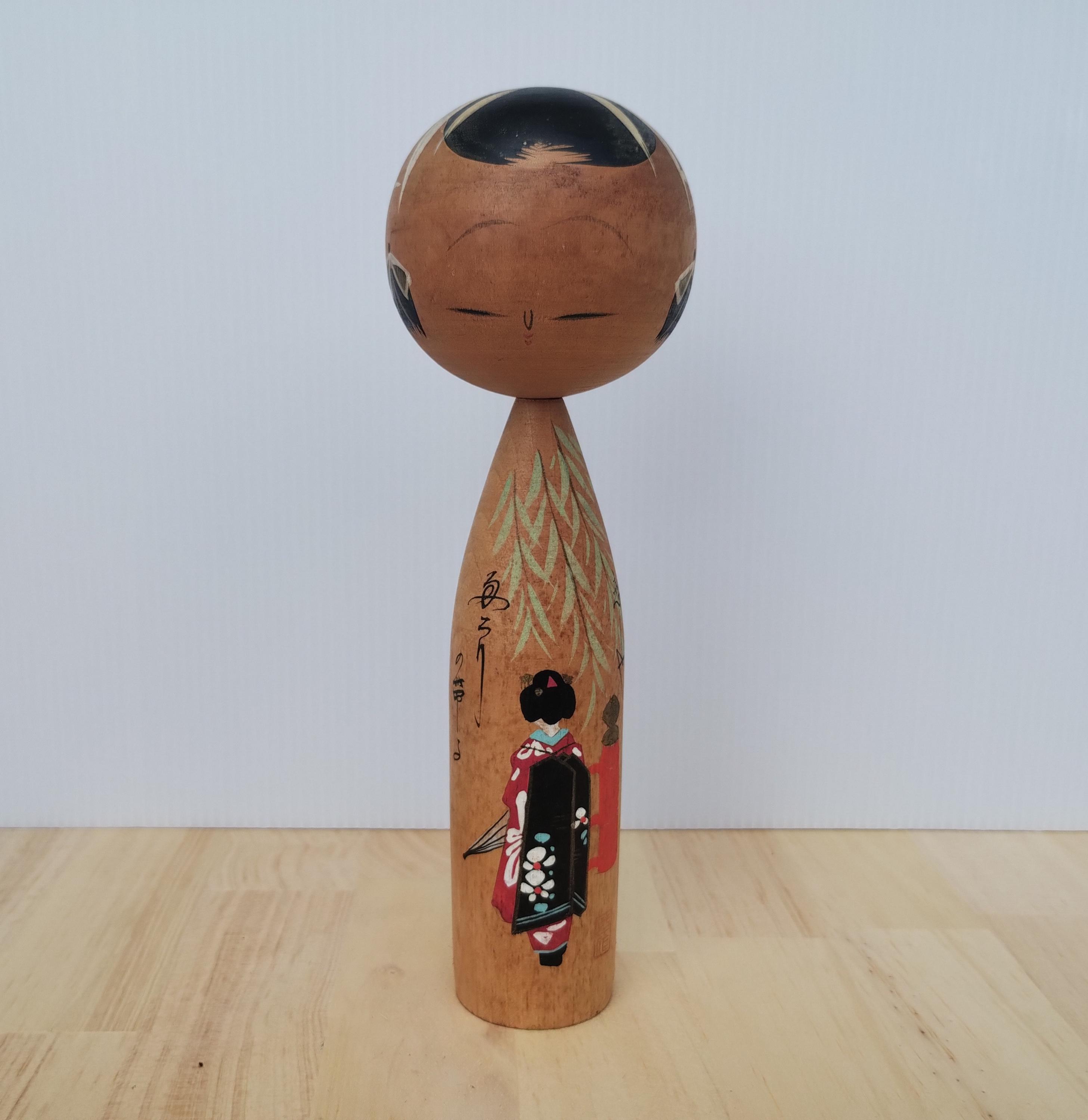 Poupée japonaise vintage sur un socle en bois recouvert de