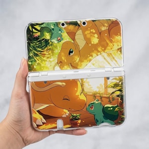 Puede incluir: Una funda protectora transparente para un dispositivo de juego portátil, con una colorida ilustración de personajes de dibujos animados. El diseño incluye una criatura parecida a un dragón, una criatura verde parecida a una planta y una escena exterior soleada.
