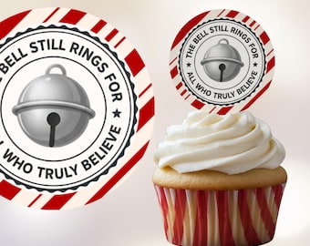 May include: A cupcake with white frosting and a red and white striped liner. Two circular toppers feature a silver bell graphic and the text "THE BELL STILL RINGS FOR ALL WHO TRULY BELIEVE" in a circular design with red and white stripes.