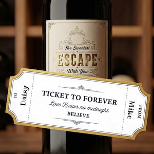 May include: A wine bottle with a label that reads "The Sweetest Escape With You." A ticket-shaped card is in front of the bottle, with the words "Ticket to Forever" and "Believe." The card is addressed "To Daisy" and "From Mike."
