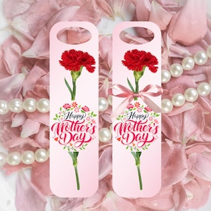May include: Two pink Mother's Day gift tags with a red carnation flower illustration. The tags have a floral wreath design with the text "Happy Mother's Day". One tag has a pink ribbon. The background features pink flower petals and a pearl necklace.