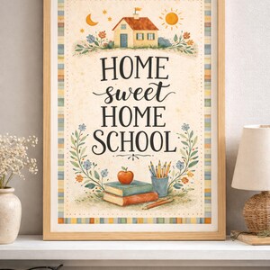 May include: A framed print with the words "HOME sweet HOME SCHOOL" in a decorative font. The artwork features a house, sun, moon, flowers, books, pencils, and an apple. The frame is a light brown color.