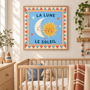 May include: A square wall art print featuring a light blue background with a smiling crescent moon and a yellow sun. The text LA LUNE and LE SOLEIL is printed in dark blue. The border consists of red and teal triangles on a cream frame.