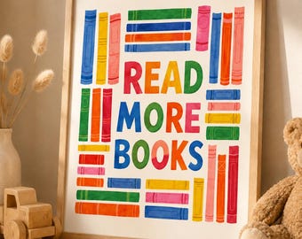 Può includere: Una stampa artistica incorniciata con la scritta "READ MORE BOOKS" in lettere colorate. L'opera presenta libri illustrati in vari colori, tra cui blu, verde, arancione e rosa, disposti attorno al testo. La cornice è in legno chiaro.