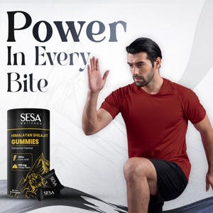 Puede incluir: Un anuncio con un hombre con una camisa roja y pantalones cortos negros, con el texto "Power In Every Bite". Un envase negro de "Himalayan Shilajit Gummies" es visible, junto con dos paquetes peque&ntilde;os. Las gomitas tienen sabor a tamarindo.