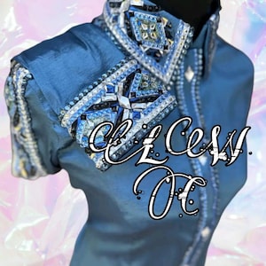 May include: A blue shirt with intricate embellishments on the collar and sleeves. The collar and cuffs are adorned with a pattern of blue, silver, and clear rhinestones. The text "Access OC" is written across the front.