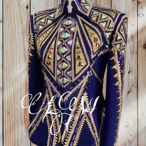 May include: A navy blue show jacket with intricate gold and iridescent embellishments. The jacket features a high collar and long sleeves, with a geometric design of gold and crystal accents. The text "CeCe's Kloset" is visible on the front.