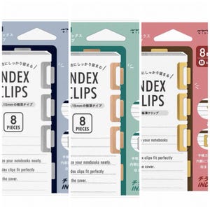Può includere: Un set di tre confezioni di clip per indici in blu, verde e rosa. Ogni confezione mostra "INDEX CLIPS" e "8 PIECES". Le clip sono progettate per organizzare i quaderni in modo ordinato e si adattano perfettamente alla copertina.