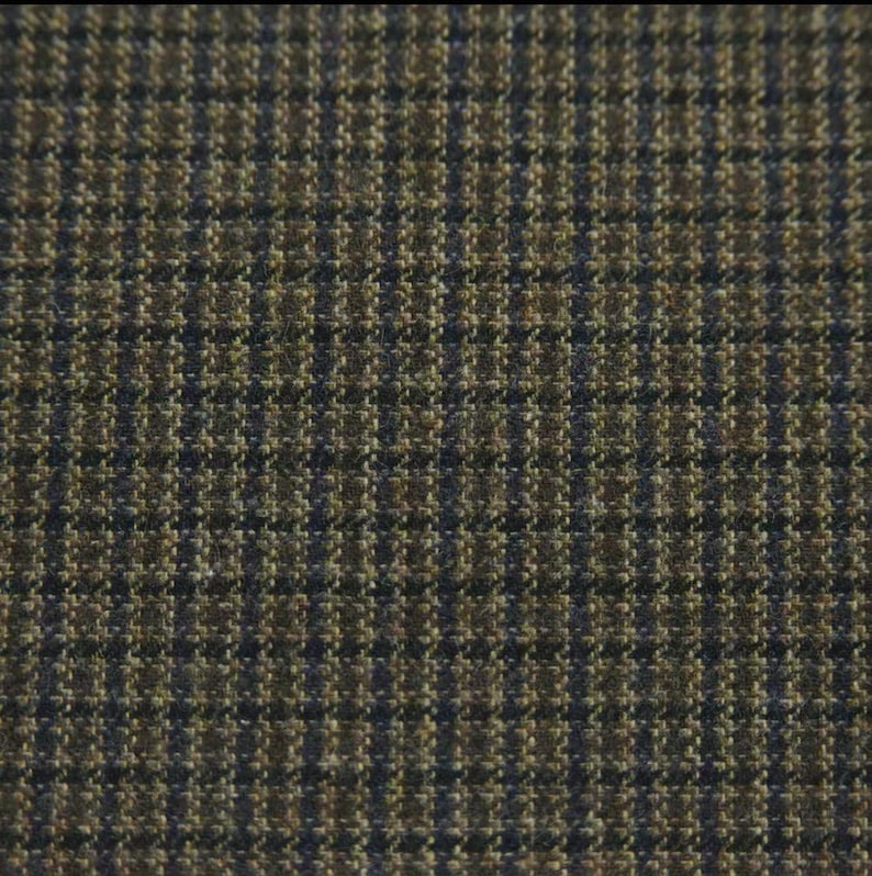 May include: Close-up of a woven fabric with a small, repeating check pattern. The fabric features a combination of brown, olive green, and navy blue threads, creating a textured appearance. The pattern is consistent across the entire surface.