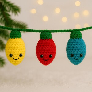 May include: A string of three crocheted Christmas light ornaments. The lights are yellow, red, and blue, each with a green cap and a smiling face. The lights are strung on a green crocheted cord.