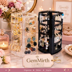 May include: Two rotating jewelry organizers, one clear and one black, featuring multiple tiers with perforated edges for hanging earrings. A rectangular tag in the foreground displays the text GemMirth Sparkle Every Day, Organize, Shine, Inspire.