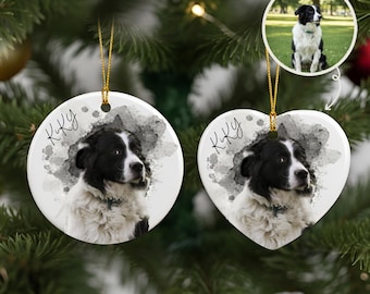 May include: Two white ceramic dog ornaments, one round and one heart-shaped, hang from gold strings. Each features a black and white dog portrait with the name "Kiky" and a watercolor-style gray background. A small photo of the dog is in the background.