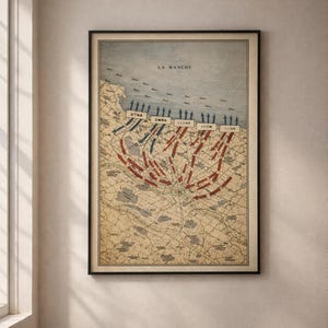 Pode incluir: Impressão emoldurada de mapa vintage retratando uma estratégia militar com setas e texto. O mapa, em tons de bege, azul e vermelho, mostra o Canal da Mancha com o texto "LA MANCHE" no topo. A impressão está em uma moldura preta.