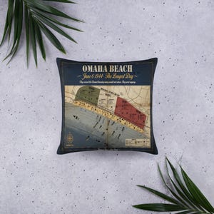 Pode incluir: Uma almofada quadrada com um mapa histórico de Omaha Beach em 6 de junho de 1944. O design inclui o texto Omaha Beach, 6 de junho de 1944, The Longest Day, e They crossed the Channel knowing many would not return. They went anyway.