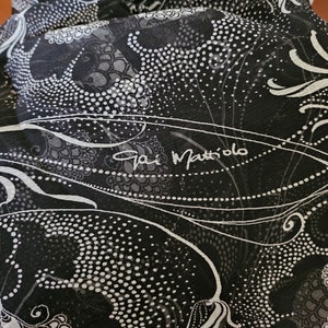 Puede incluir: Bufanda de seda con estampado en blanco y negro con un diseño floral blanco y el texto "Gai Mattiolo" en blanco.