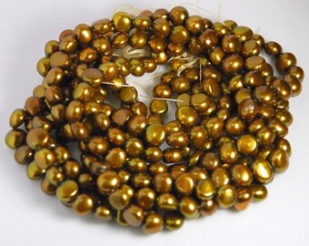 May include: A strand of brown iridescent pearls. The pearls are round and have a smooth, shiny finish.