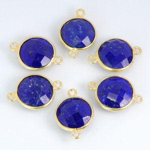 Pode incluir: Seis pingentes redondos de conex&atilde;o de pedra preciosa em tom dourado com uma pedra de l&aacute;pis-laz&uacute;li em cada um. As pedras s&atilde;o facetadas e t&ecirc;m uma cor azul profunda.