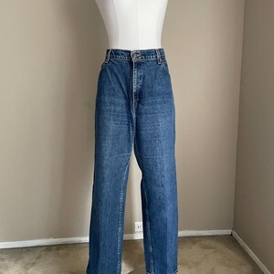 Peut inclure: Un jean bleu denim &agrave; taille haute et &agrave; jambe droite. Le jean est sur un mannequin.