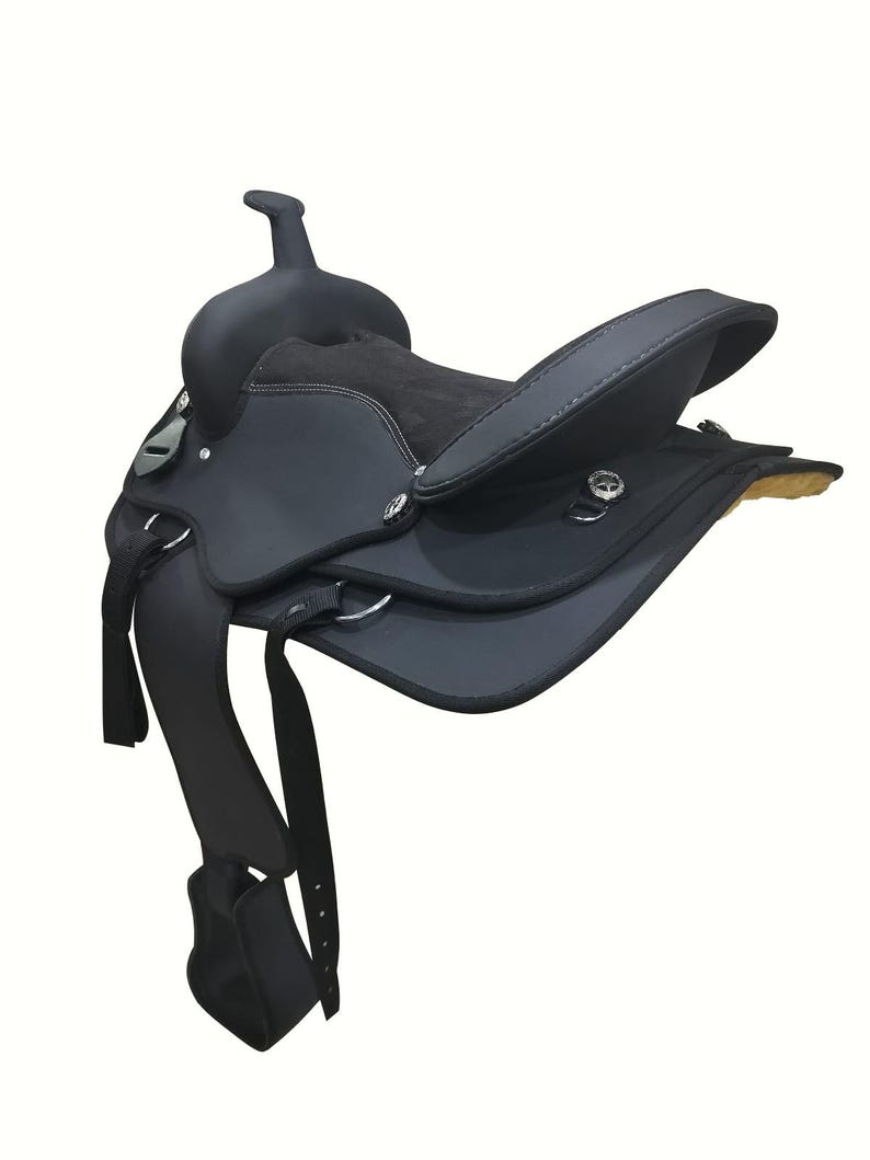 May include: A black western saddle with a high cantle and horn. The saddle features a padded seat, stirrups, and various straps and buckles. The leather appears to be in good condition, and the saddle is designed for riding horses.