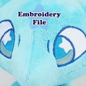 Puede incluir: Juguete de peluche azul bordado con ojos blancos. Los ojos tienen un contorno azul y plateado. El texto "Embroidery File" es visible en la imagen.