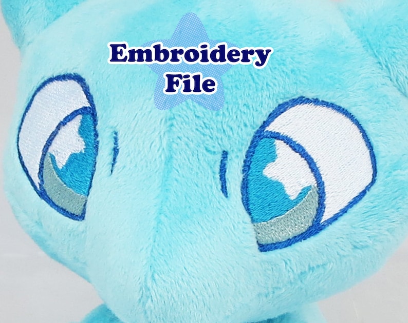 May include: Embroidered blue plush toy with white eyes. The eyes have a blue and silver outline. The text "Embroidery File" is visible in the image.