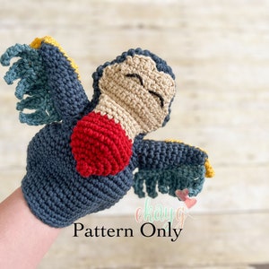 May include: Crochet amigurumi pattern for a blue, red, and beige bird with yellow accents. The bird has a closed eye expression and is holding its wings out. The text "Pattern Only" is visible in the image.
