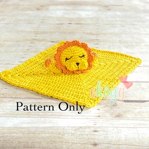 May include: A crocheted lion baby blanket with a yellow blanket and an orange lion head with closed eyes. The text "Pattern Only" is written below the blanket.