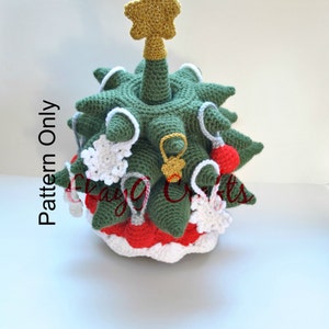 May include: A crocheted Christmas tree with a gold star on top. The tree is decorated with red and white baubles and snowflakes. The tree is green and white.