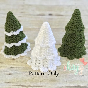 May include: Three crocheted Christmas trees, one white and two green, with white crocheted trim around the bottom of each tree. The trees are sitting on a wooden surface. The text "Pattern Only" is printed below the trees.