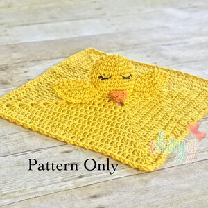May include: A yellow crocheted baby blanket with a yellow crocheted chick attached. The blanket has a square shape and the chick has closed eyes. The text "Pattern Only" is printed below the blanket.