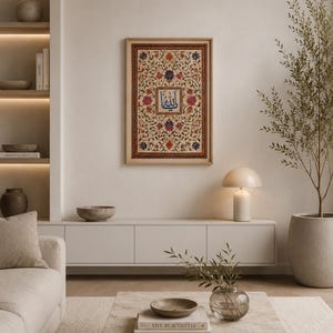 May include: A rectangular framed wall art piece featuring intricate floral patterns in shades of red, blue, and green surrounding a central square panel with blue Arabic calligraphy. The artwork is enclosed in a light-toned wooden frame.